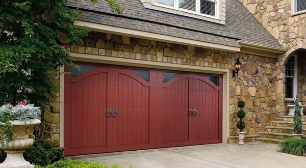 Amarr garage door in red with decorative hardware and stone facade in San Jose, CA