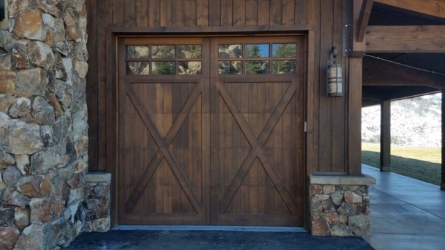 Rustic carriage house door with wood panels and decorative window in San Jose, CA
