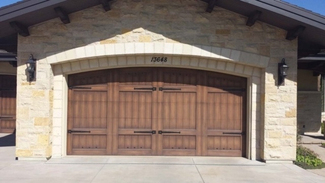 Stone garage featuring a carriage house door and a curved entry in San Jose, CA